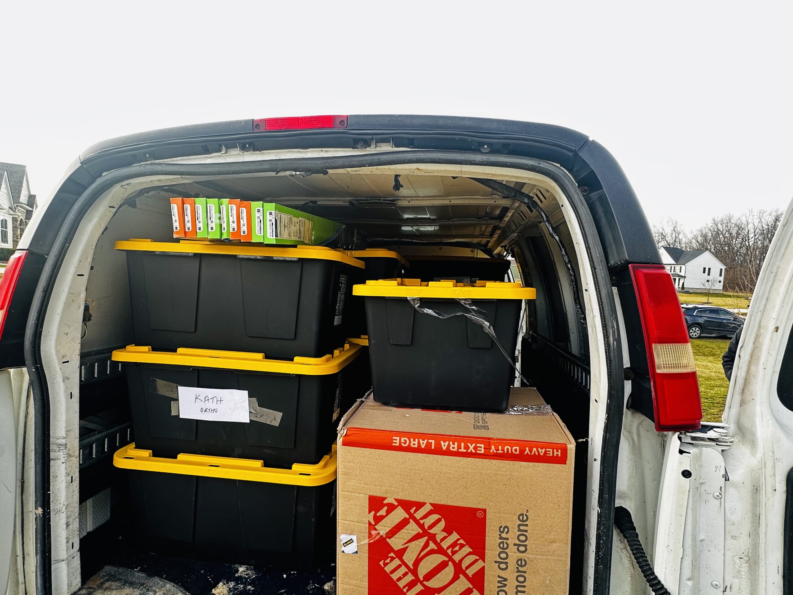 Cargo van packed with medical supply bins labeled KATH ORTHO