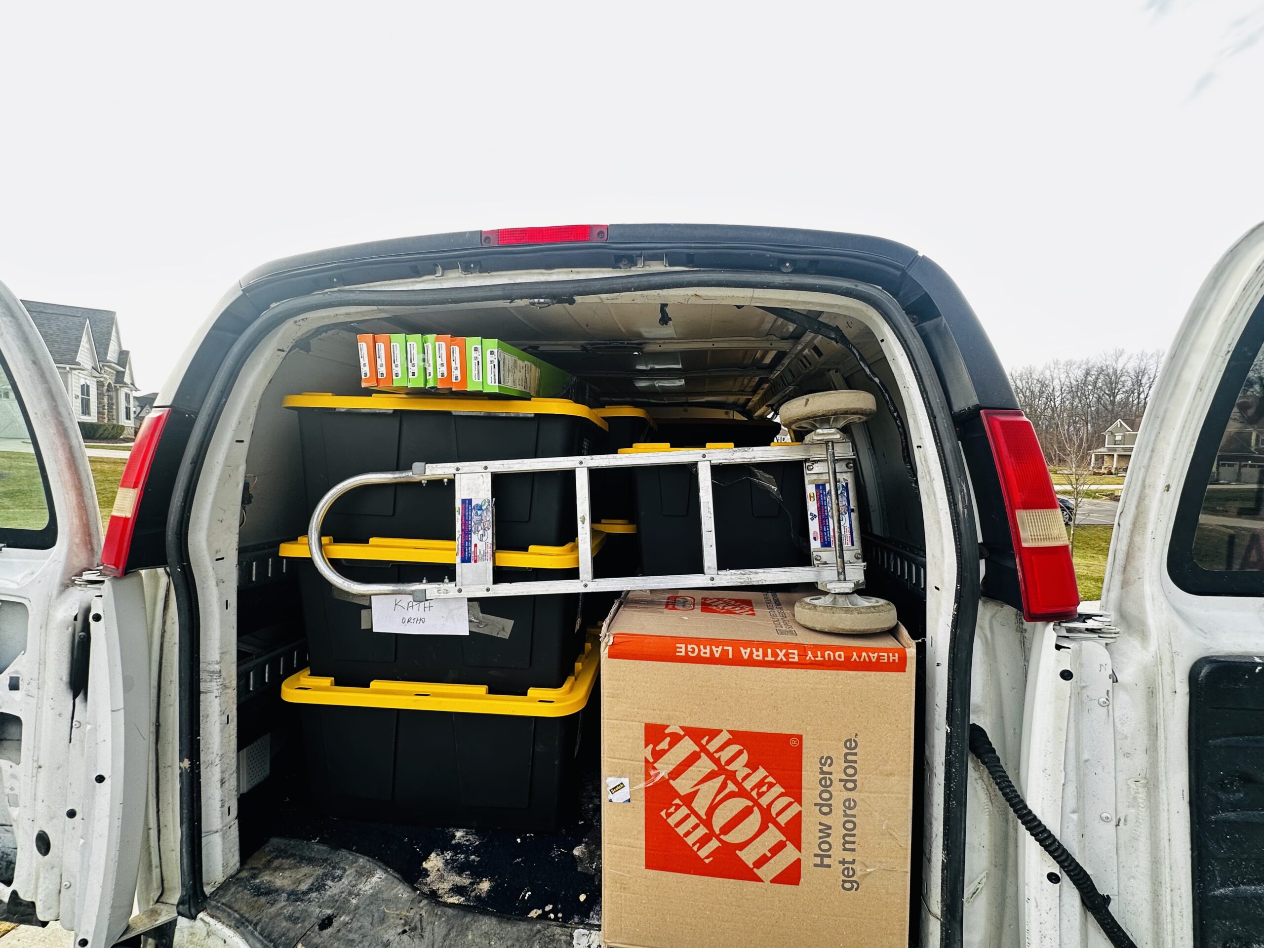 Open cargo van packed with labeled medical supply bins and boxes